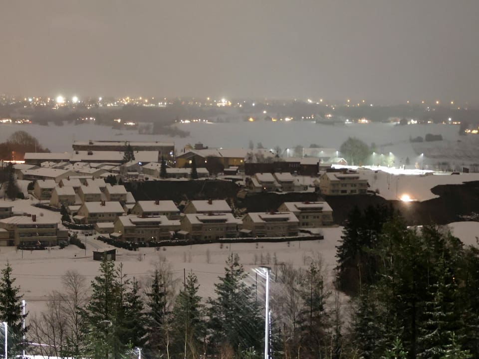 Schneebedecktes Dorf im Dunkeln