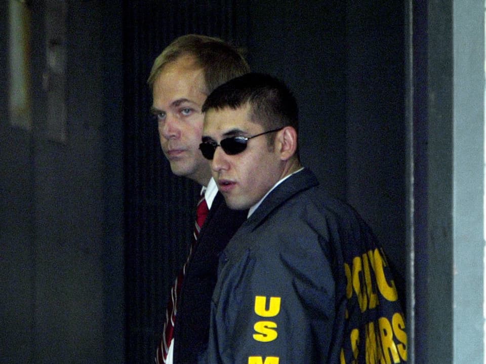 Hinckley wird 2003 von einem US-Marshall ins Gerichtsgebäude begleitet.