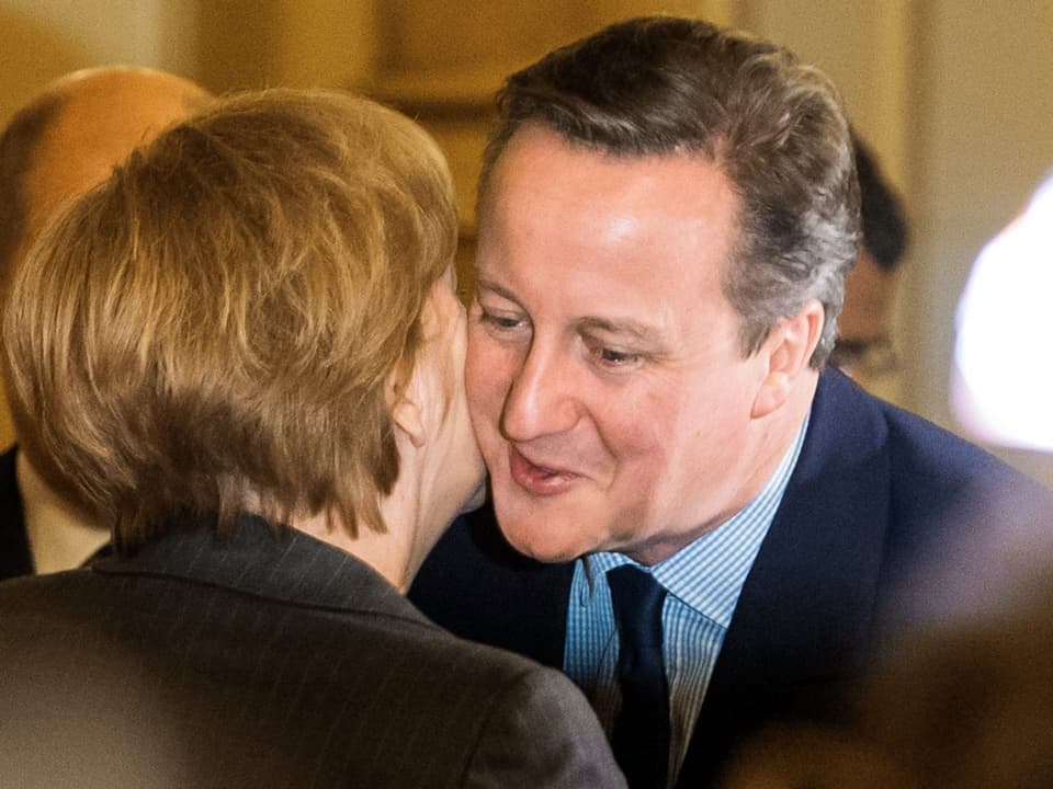 Premier Cameron (rechts) und die deutsche Kanzlerin Merkel (links) geben sich ein Wangenküsschen.