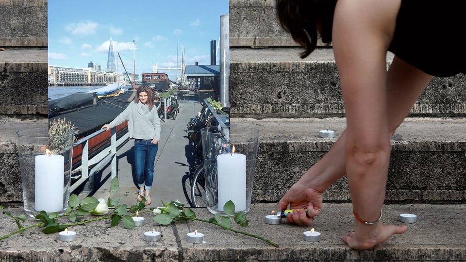 Eine Frau zündet Kerzen vor einem Bild von Jo Cox an