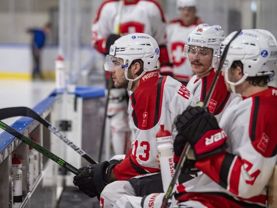 Abermals Bestandteil des Prospect Camps Eishockeyspieler sitzen auf der Bank