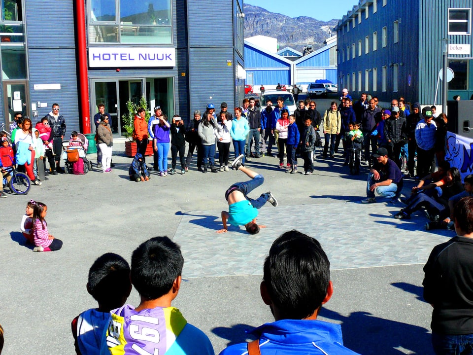 Junge Braekdancer auf einem Platz, Publikum steht im Kreis