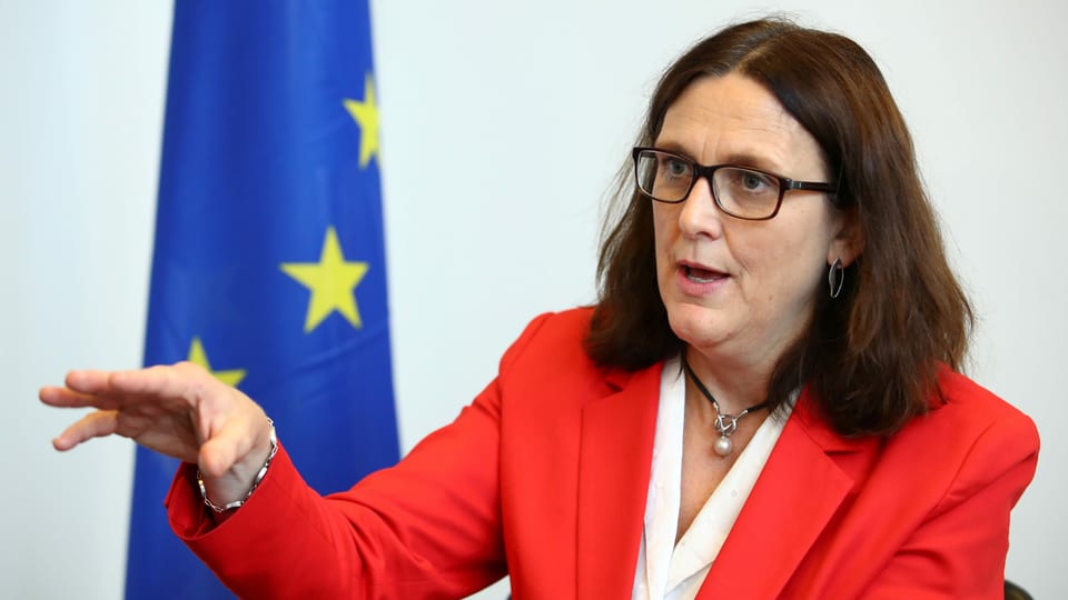 Cecilia Malmström in Genf, im roten Jacket vor der EU-Flagge