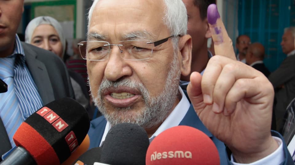 Rached Ghannouchi, zeigt seinen Zeigefinger mit der Stempelfarbe.