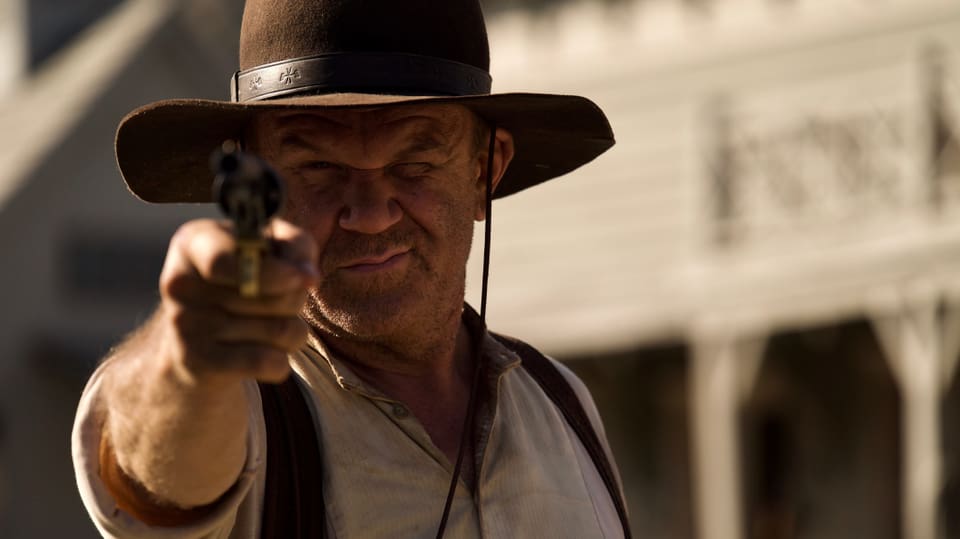 Ein Cowboy zielt mit seinem Revolver direkt auf die Kamera.