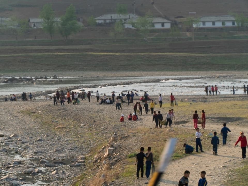Menschen an einem Flussbett