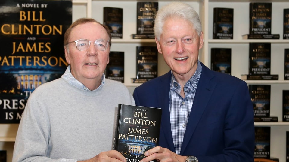 James Patterson und Bill Clinton halten ihren Krimi in die Kamera.