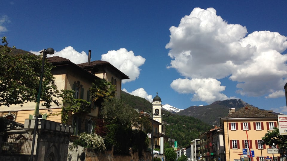 Das Dorf Minusio. Blauer Himmel mit grauen Quellwolken.