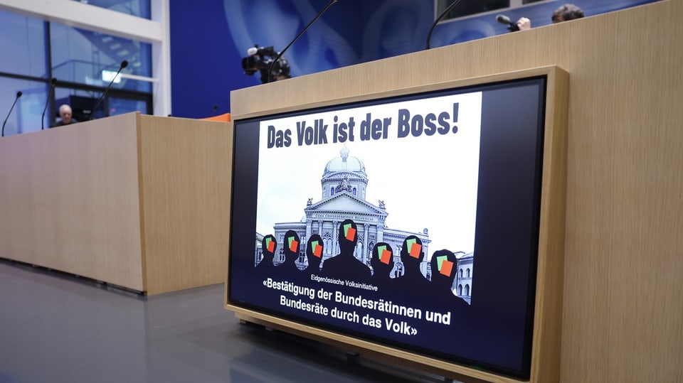 Eine Grafik «Das Volk ist der Boss!» wird während der Medienkonferenz auf einem Bildschirm angezeigt. 