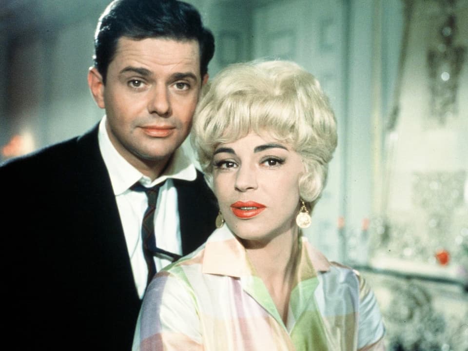 Dunkelhaariger Mann mit Krawatte neben blonder Frau mit Blues aus einem 60er-Jahre-Film.