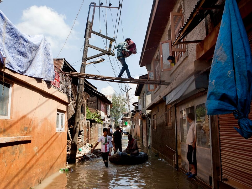 Mann auf einer Leiter über dem Hochwasser
