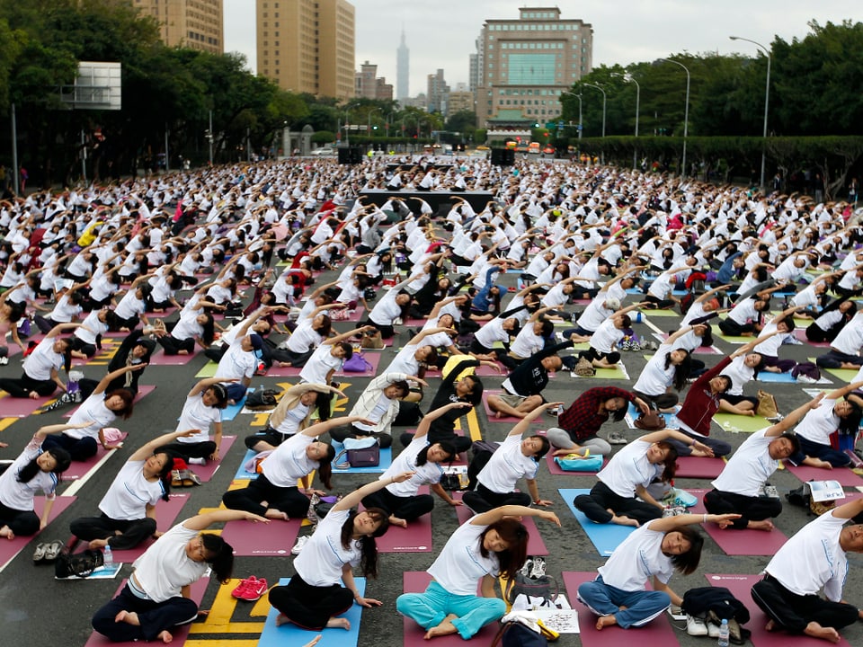 Tausende Menschen bei einer Yoga-Übung im Freien