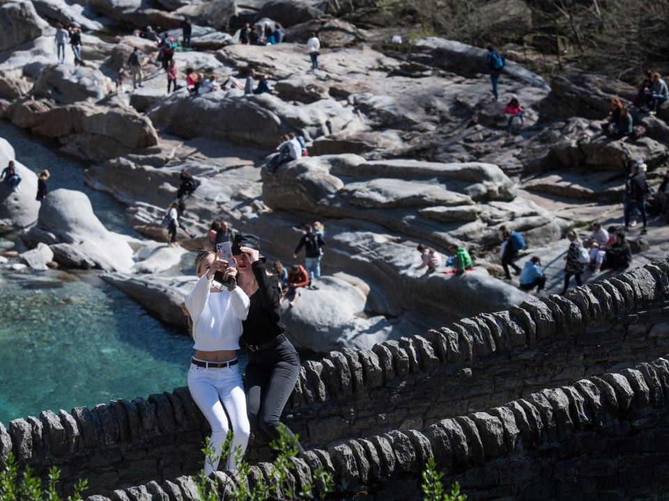 Zwei Touristinnen machen auf der Brücke ein Selfie.