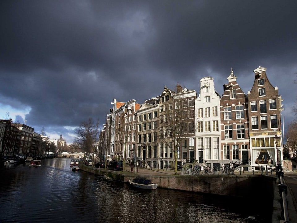 Die Amsterdamer Keizersgracht vor grauem Himmel.