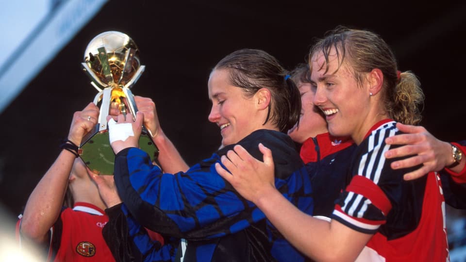 Zwei Fussballerinnen mit einem Pokal.