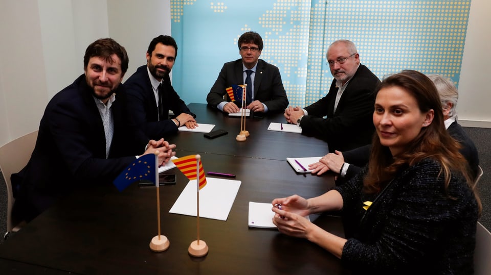 Verschiedene katalanische Politiker sitzen mit Carles Puigdemont an einem Tisch.