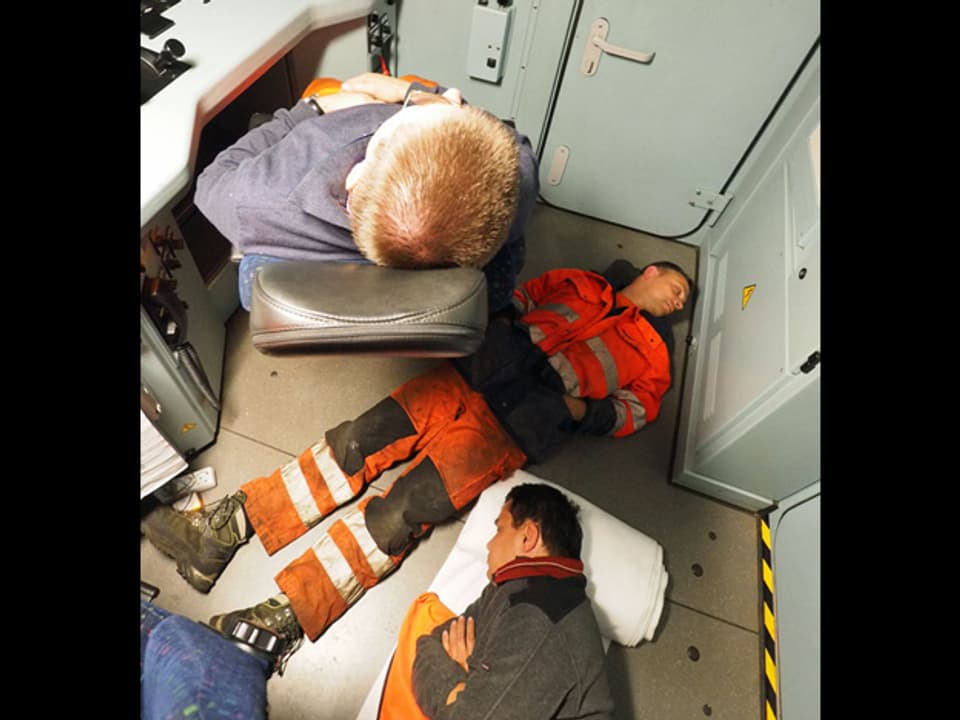 Drei Männer beim Schlafen im Führerstand.