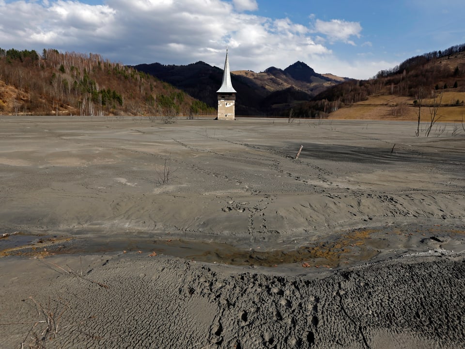 Kirchenturm ragt aus See mit Abfallprodukten einer Mine