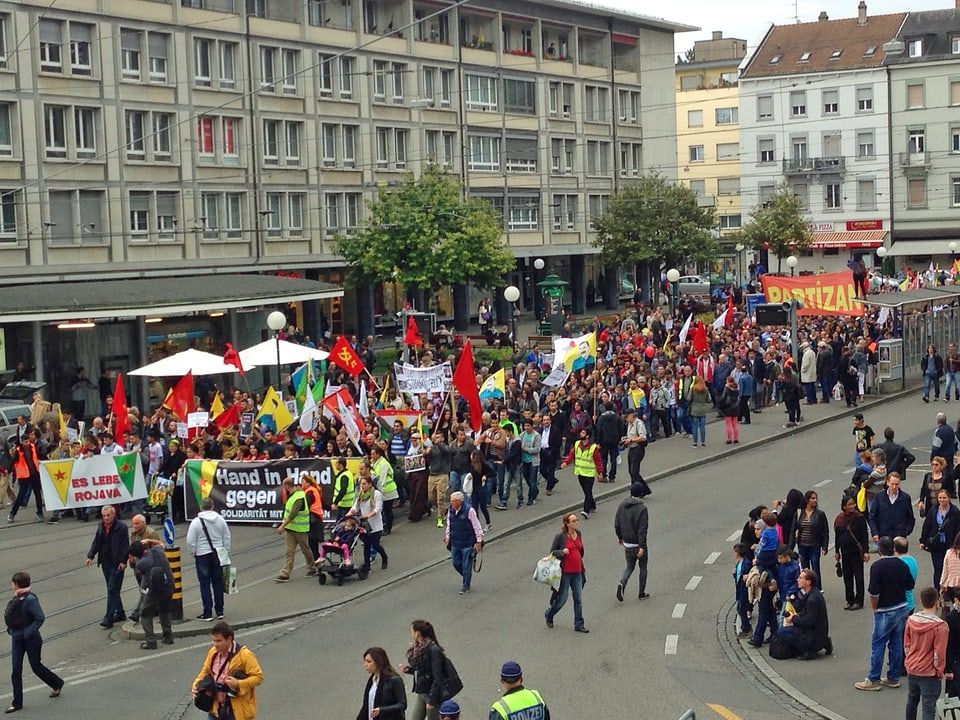 Demonstranten mit Fahnen ziehen durch Basel