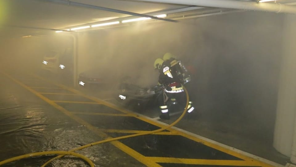 Feuewehrleute löschen das brennende Auto im Parkhaus des Einkaufszentrums Tivoli (Kapo Aargau)