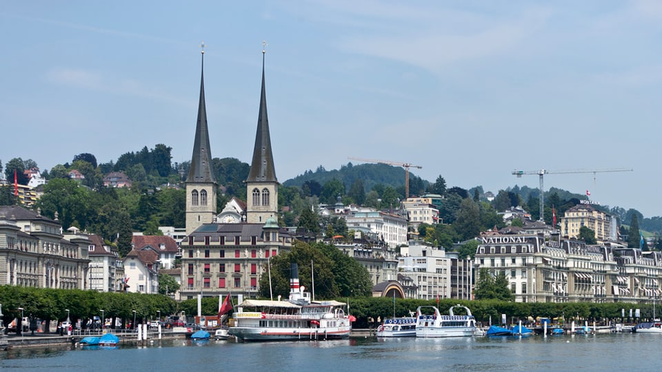 Die Hofkirch in Luzern mit Booten im Vordergrund.