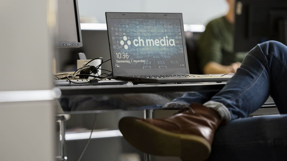 Ein Mitarbeiter sitzt vor einem Bildschirm, auf dem CH Media steht.