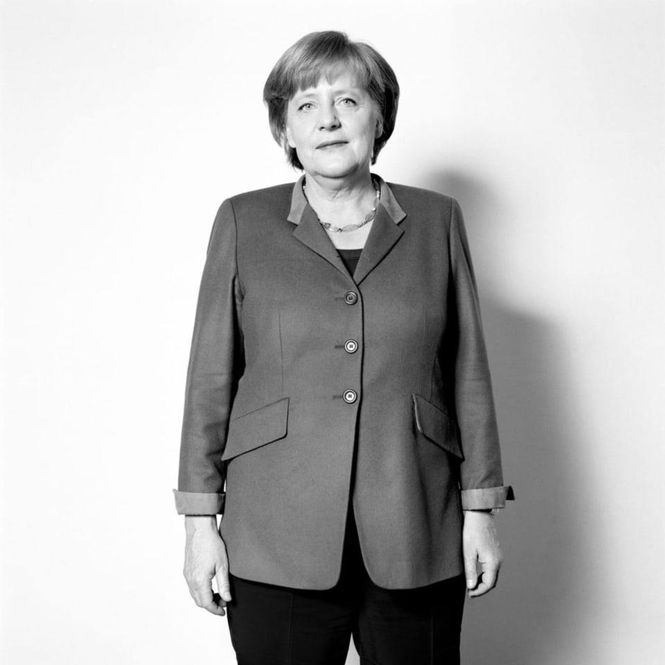 Politikerin Angela Merkel mit Blazer vor weissem Hintergrund.