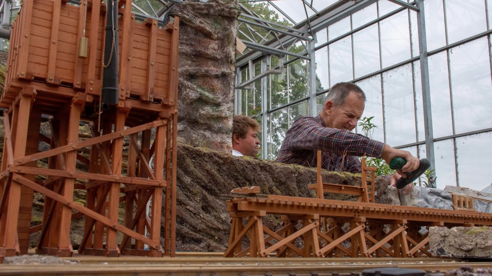 Modellbauer arbeitet an seiner Gartenbahn