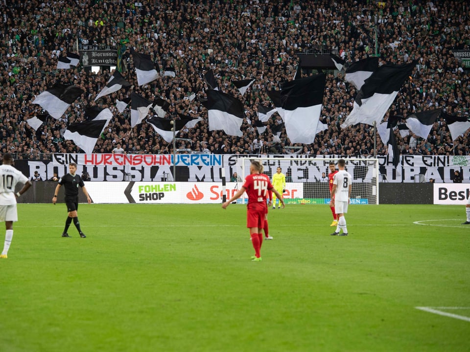 Gladbach-Fans mit einem Plakat, auf diesem steht: «Ein Hurensohn-Verein stellt nur Hurensöhne ein.» 