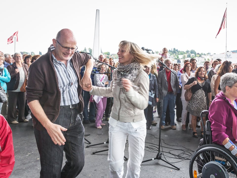 Ein Paar tanzt auf dem Europaplatz vor einer Menge Zuschauer zur Musik von Carlos Martinez und Band.