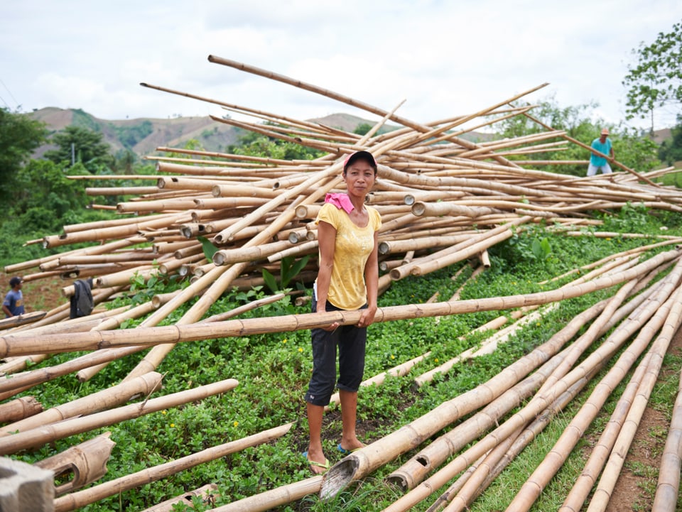 Junge Frau hält ein langes Bambusrohr