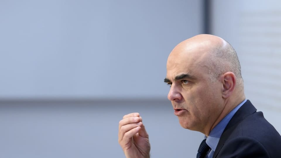 Alain Berset ist von der Seite zu sehen. Er hält eine Hand empor während er spricht.