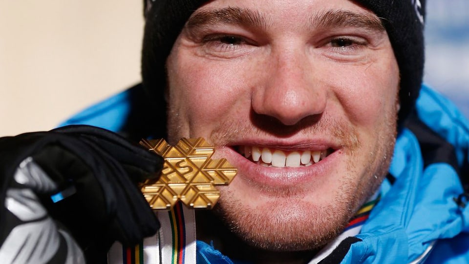 Mann zeigt stolz seine Goldmedaille
