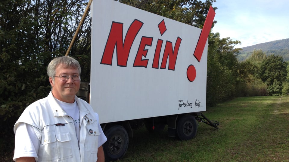 Raphael Steiner steht ausserdem von Meinisberg vor dem Plakat mit der Aufschrift «Nein - Fortsetzung folgt», welches den Widerstand gegen den Fahrenden-Durchgangsplatz symbolisiert.