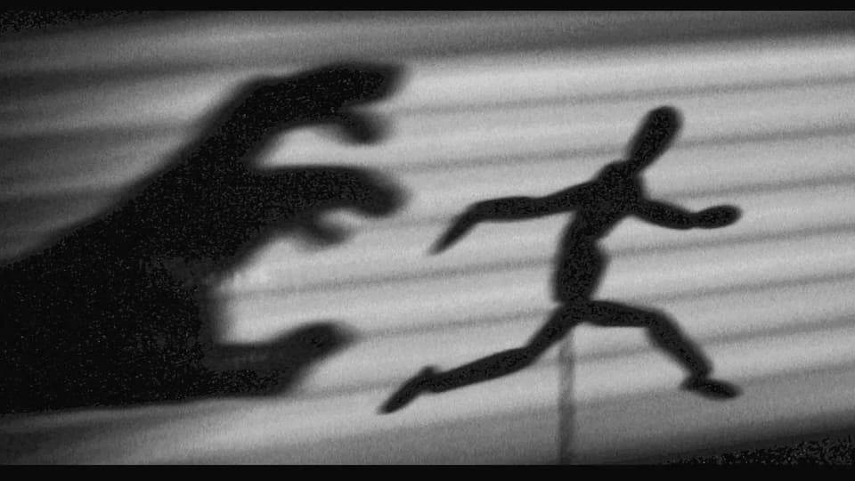 Schattenbild: Eine Hand greift nach einer rennenden Person.