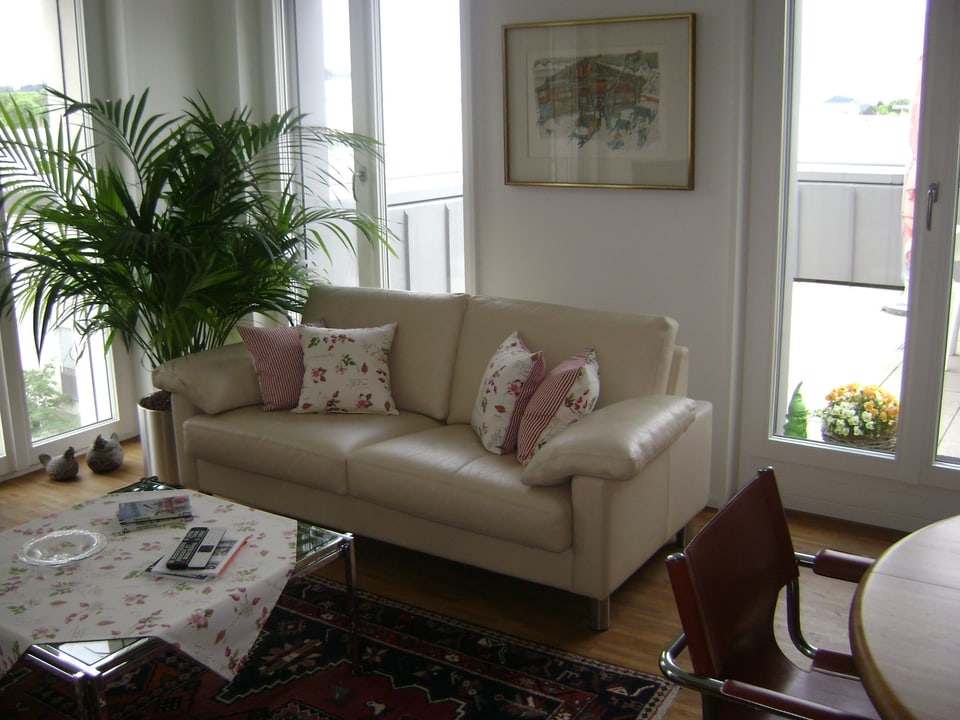Sofa, Palme, Bild von Carigiet, Hühner, Tisch, Blick auf Terrasse.