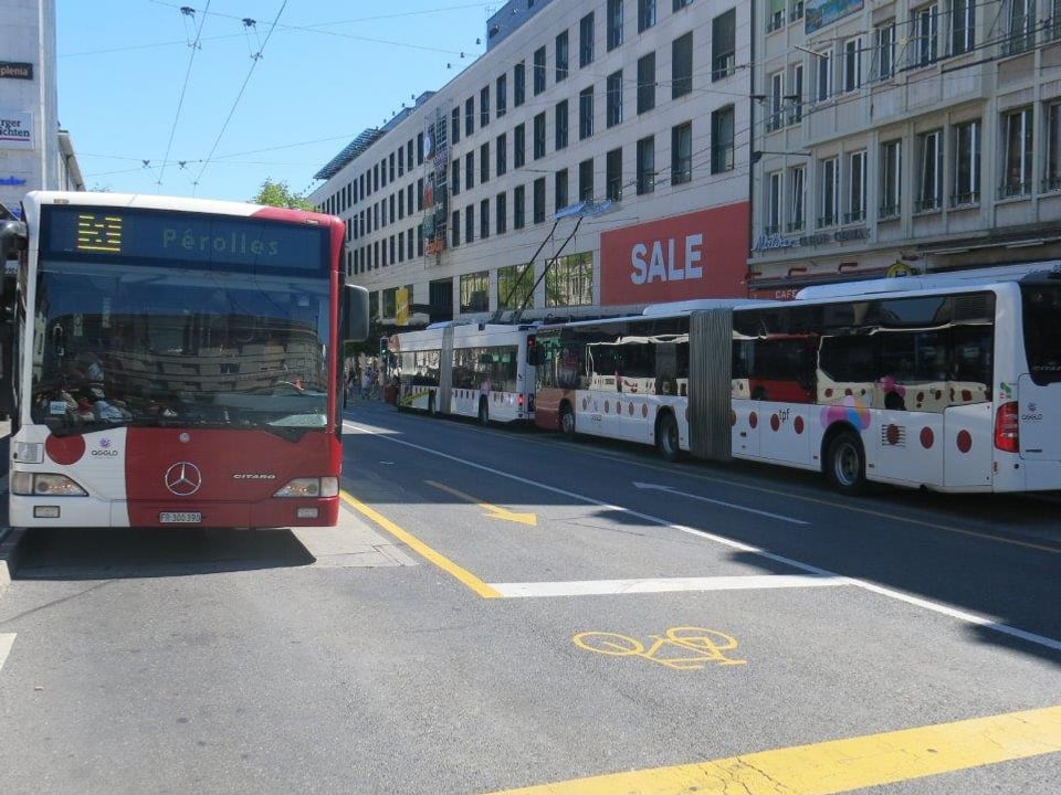 Busse stehen an zwei Haltestellen.