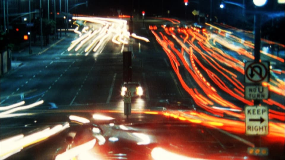 Langzeitbelichtung: Lichtspuren von Autos auf einer nächtlichen Strasse