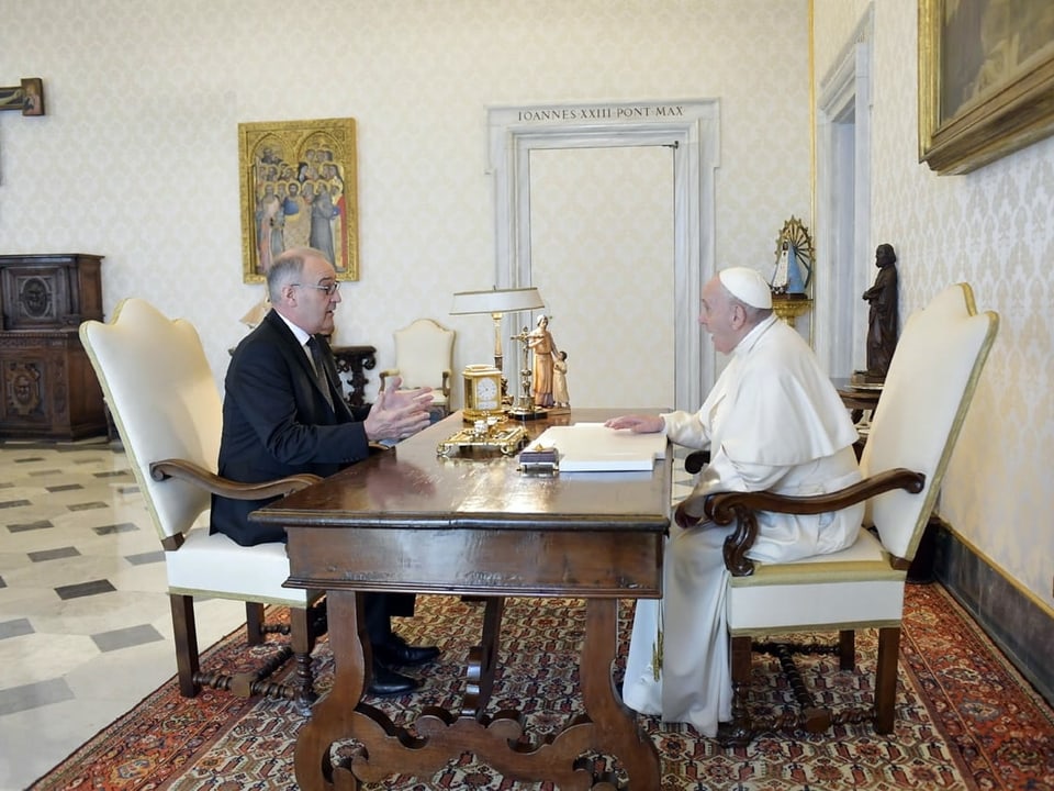Guy Parmelin und Papst Franziskus vis a vis an einem Tisch.