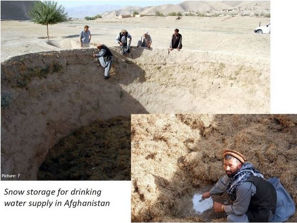 Grosses leeres Loch in einer wüstenähnlichen Landschaft. Am Rand sitzen Afghanen, eine Person klettert hinunter.