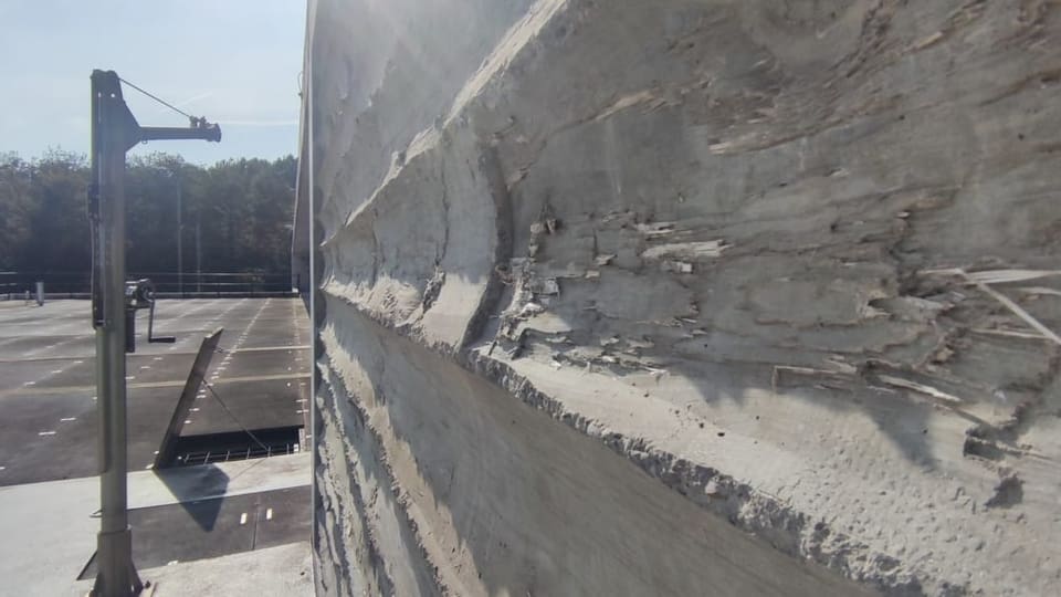 Betonwand mit sichtbaren Spuren von Baumstämmen.