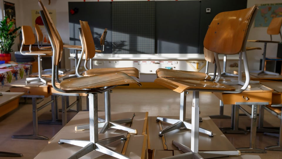 Blick in ein Klassenzimmer, in welchem die Stühle auf die Tische gestellt sind.