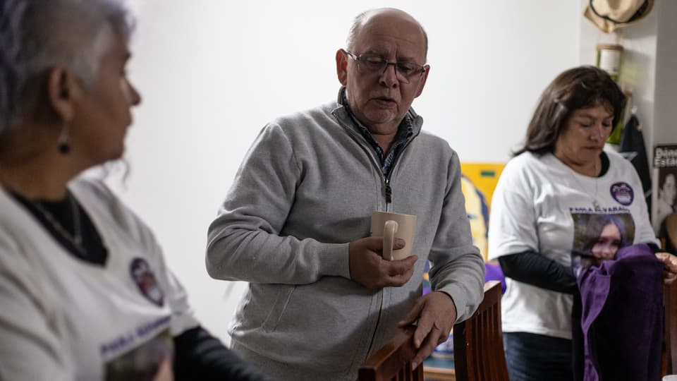 Walter Uribe Troncoso, familiares de otras víctimas a su izquierda y derecha.
