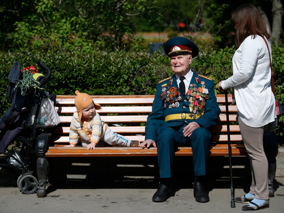 Ein Veteran sitzt auf einer Parkbank.