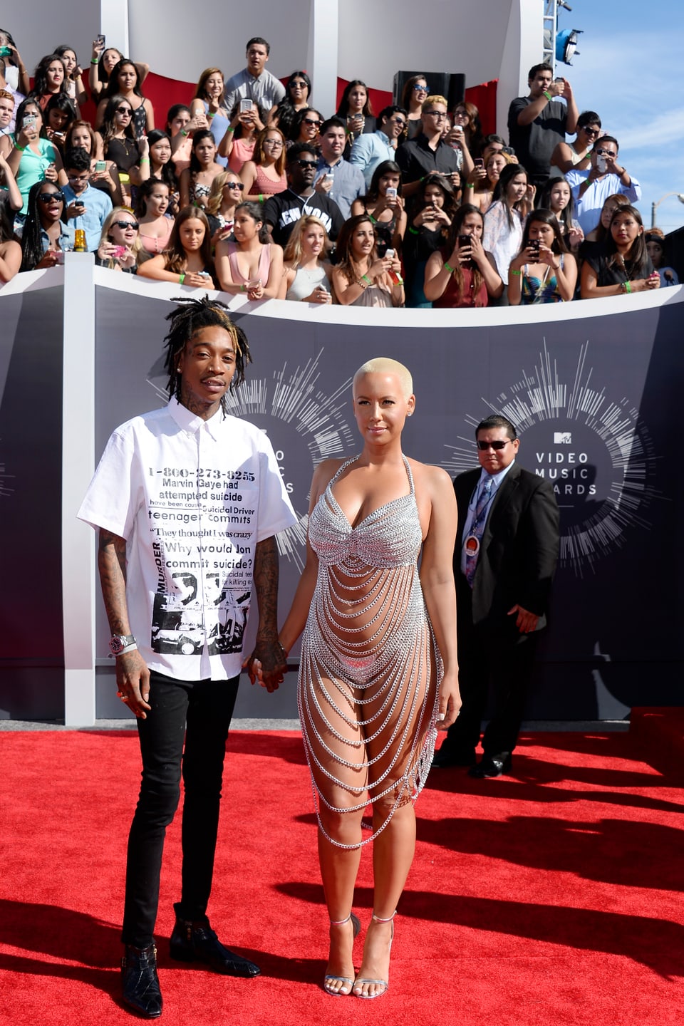 Wiz Khalifa in Jeans und Shirt und Amber Rose in silbernem Nichts auf dem roten Teppich der VMAs