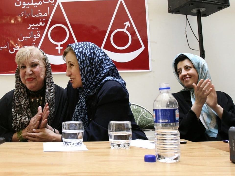Drei Frauen sitzen zusammen an einem Konferenztisch