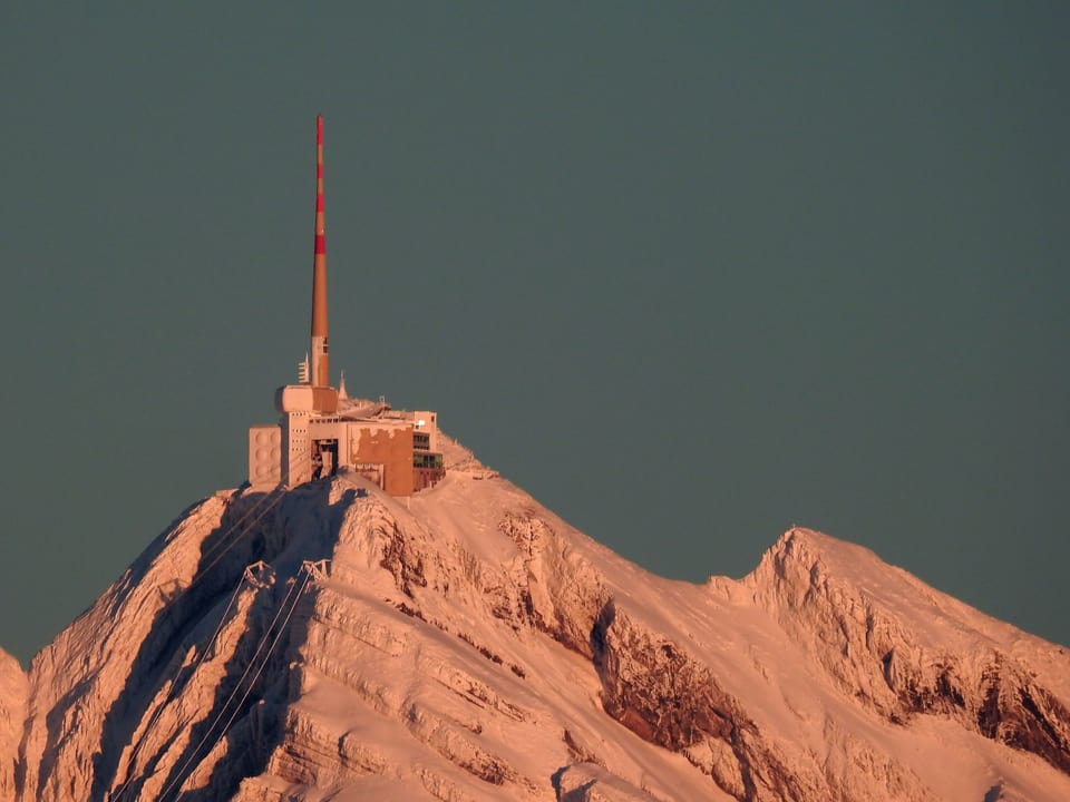 Verschneite Bergspitze mit den Säntisgebäuden und Antenne auf der Spitze
