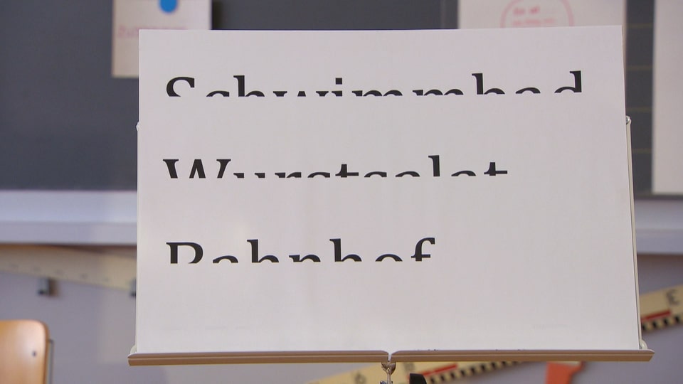 Ein Blatt mit drei horizontal halbierten Wörtern: Schwimmbad, Wurstsalat und Bahnhof