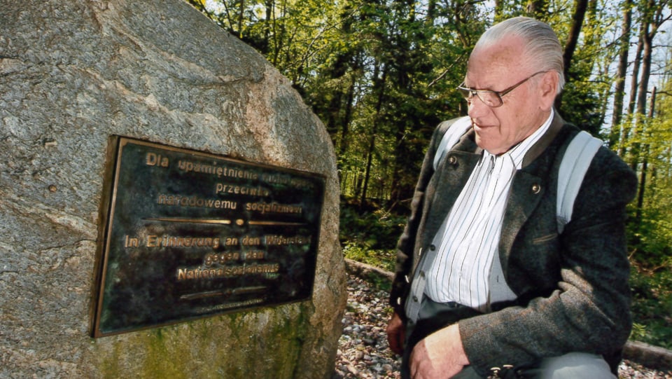 Salterberg kniet neben einem Stein mit der Auffschrift "In Erinnerung an den Widerstand gegen den Nationalsozialismus".