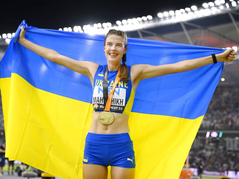 Mahutschich mit der WM-Goldmedaille und ukrainischen Flagge am Jubeln.